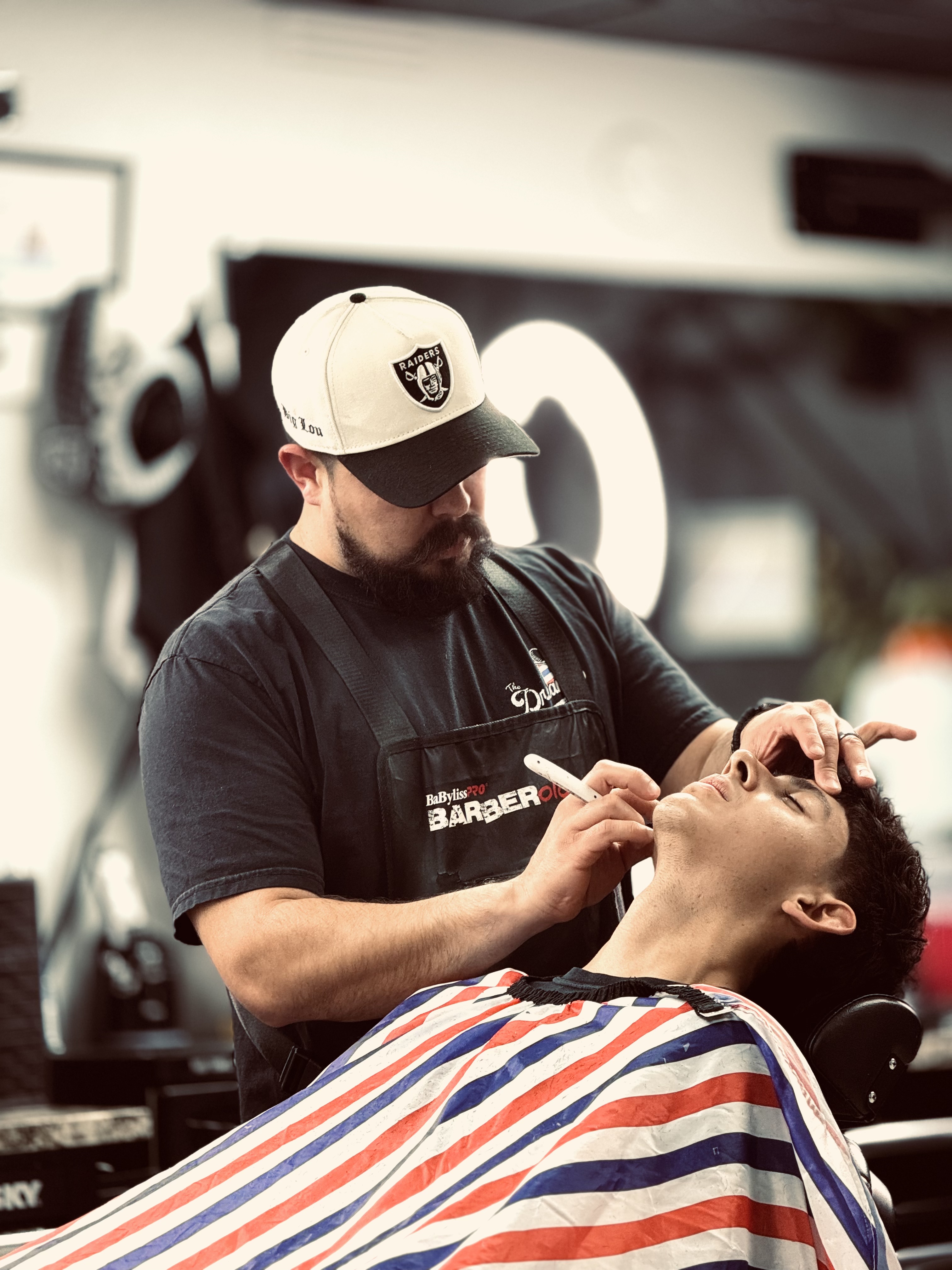 Luis Zuniga cutting a client's hair at The Dreamerz Barbershop